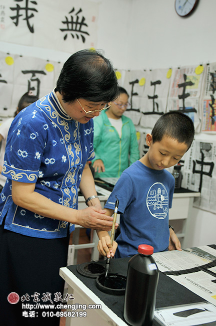杨老师纠正指导学生书写时手臂用力的方法。